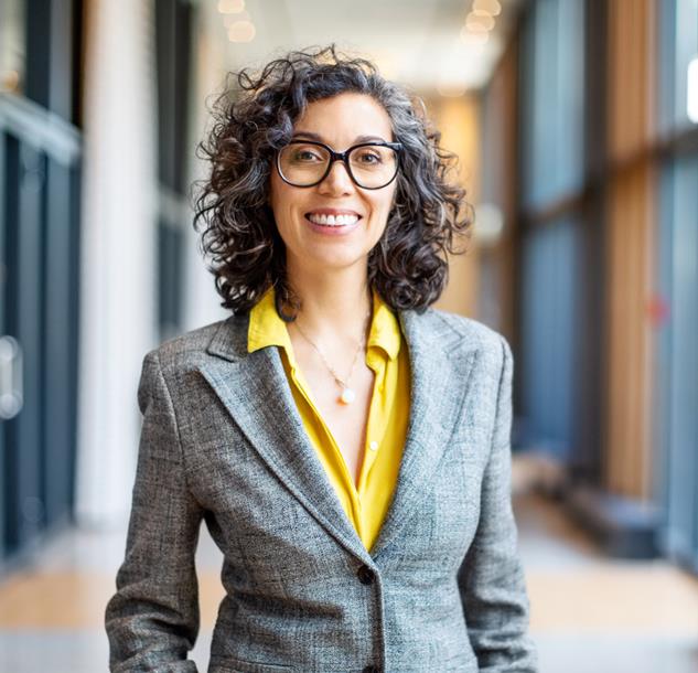 woman with dark curly hair wearing business attire